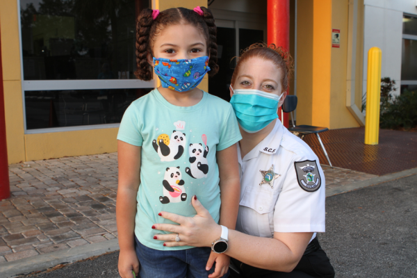 Jennifer “Lacy” Mitchell of the Sheriff’s Office of Sarasota County and her daughter Callie at the Lee Wetherington unit of the Boys & Girls Club of Sarasota with masks on to prevent the spread of COVID-19