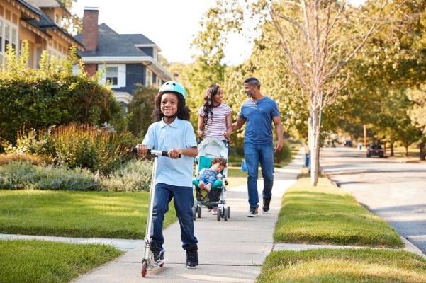 A family walks through a neighborhood like the certified Enterprise Green Communities. 