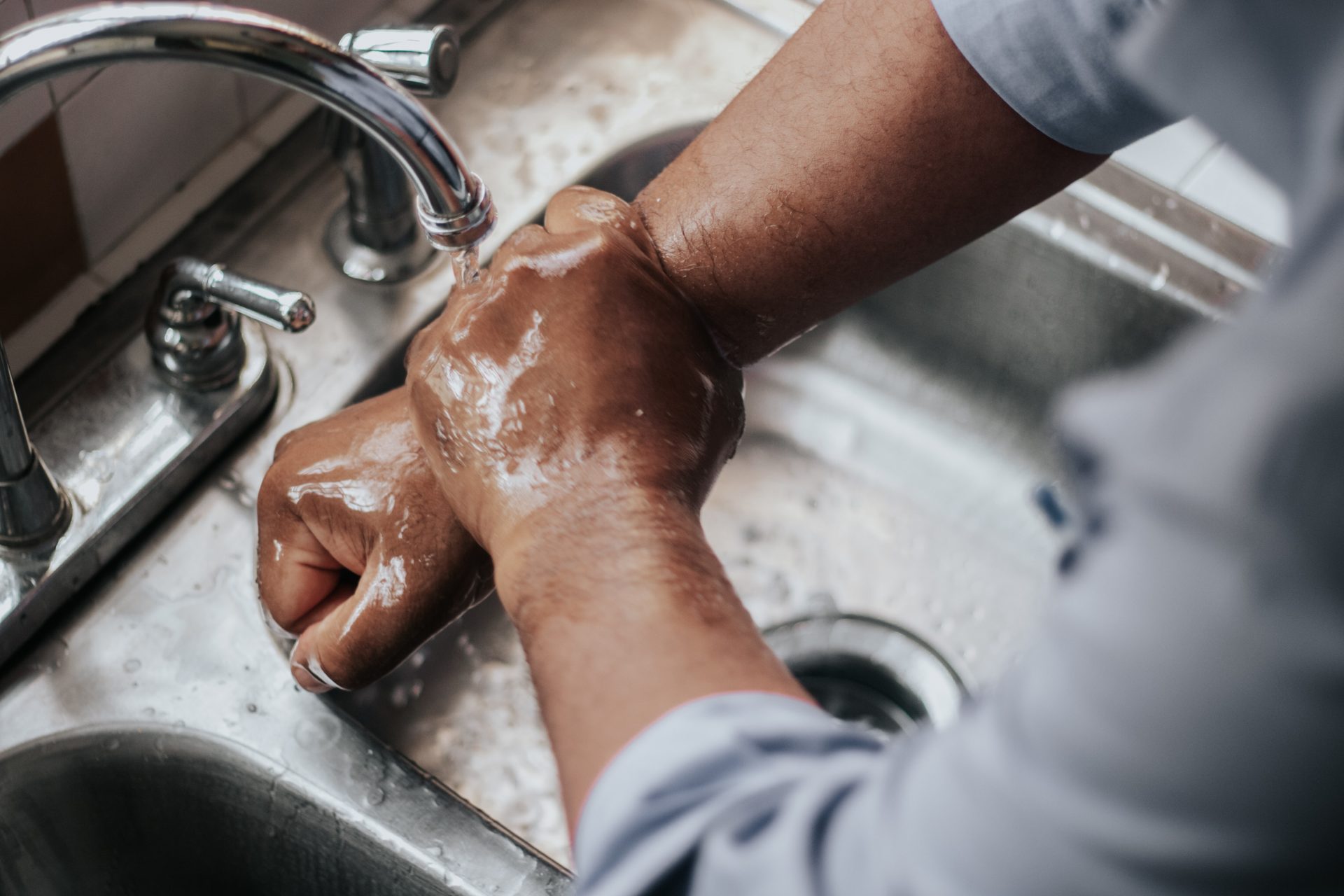 Washing hands in kitchen sink