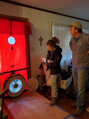 Mike Barcik and former Southface staffer Sam Morton install a custom-made insulated cover for the home’s whole-house fan.